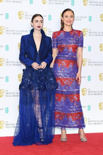 LONDON, ENGLAND - FEBRUARY 10:  Lily Collins (L) and Olga Kurylenko pose in the press room during the EE British Academy Film Awards at Royal Albert Hall on February 10, 2019 in London, England. (Photo by Pascal Le Segretain/Getty Images)