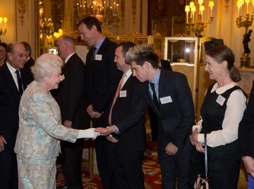 LONDON, ENGLAND - MARCH 25:  Queen Elizabeth II meets Niall Horan (2R) of One Direction at the Irish Community Reception at Buckingham Palace on March, 25, 2014. The reception is in a advance of Ireland's President Michael D Higgins who will be the first Irish President to pay a state visit to Britain in April. (Photo by Steve Parsons - WPA Pool/Getty Images)