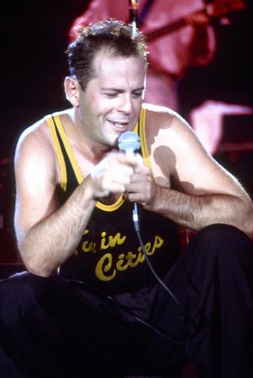 1987:  Bruce Willis wearing a Twin Cities shirt performs at the St. Paul Riverfest in St. Paul, Minnesota in July 1987. (Photo by Jim Steinfeldt/Michael Ochs Archives/Getty Images)