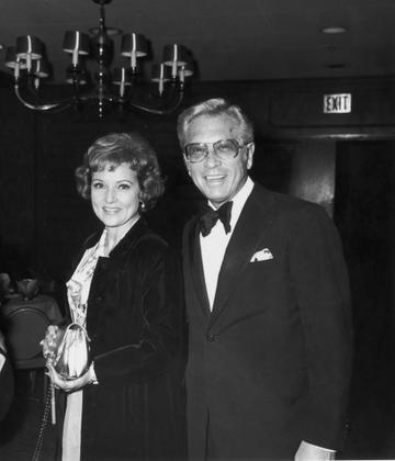 19th March 1974:  American actor Betty White stands smiling with her husband, TV producer and host Allen Ludden (d. 1981), wearing a tuxedo, at an International Broadcasting Awards dinner tribute to Mary Tyler Moore.  (Photo by Frank Edwards/Fotos International/Getty Images)