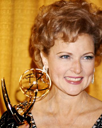 Betty White, US actress, smiling as she holds an Emmy Award, against a yellow background, USA, circa 1975. (Photo by Silver Screen Collection/Getty Images)