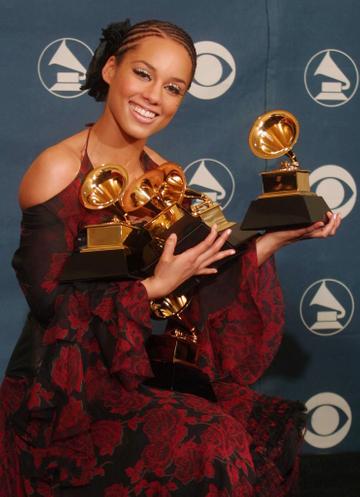 2002:  Singer Alicia Keys hold five of her Grammys at the 44th Annual Grammy Awards at the Staples Center in Los Angeles, 27 February 2002.  Keys won her Grammys for Best New Artist and Song of the Year for "Fallin".       AFP PHOTO/Lee CELANO (Photo credit should read LEE CELANO/AFP via Getty Images)