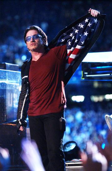 Bono, lead singer of U2, displays American flag lining in his jacket after singing "Where The Streets Have No Name", during the halftime show of Super Bowl XXXVI in the Superdome, New Orleans, Louisiana, February 3, 2002. (Photo by KMazur/WireImage)