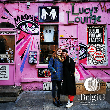 Women have often been ridiculed for liking traditionally feminine things, such as fashion and arts. Brigit 2022 aims to celebrate enjoying these feminine things by showcasing a walking tour of female-produced art around the city. Pictured are two women posing outside of Lucy's Lounge in Temple Bar, which is known for it's bright pink building and eccentric and unique grafitti.
