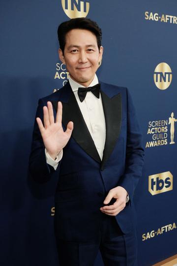 Lee Jung-jae waves at the camera, winning an award for Male Actor in a Drama Series (Photo by Kevin Mazur/Getty Images for WarnerMedia)
